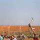 متظاهر فلسطيني يحمل علم الكويت أمام جنود الاحتلال شرق غزة- نشطاء