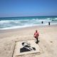 فلسطيني يرسم صورة "أردوغان" على شاطئ بحر غزة - الأناضول