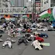متظاهرون يابانيون استلقوا في الشارع ومكثوا بصمت دون حراك مرتدين ملابس ملطخة بالدماء ورفعوا أعلام فلسطين - الأناضول
