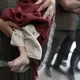 فلسطينية تحمل جثمان طفلها الشهيد جراء تجويعه في قطاع غزة- الأناضول