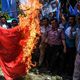 متظاهرون يحرقون علما صينيا احتجاجا على معاملة مسلمي الإيغور - جيتي