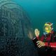 صورة لأحد الغواصين بجانب لوح يحتوي على كتابة فرعونية في قاع البحر- تويتر