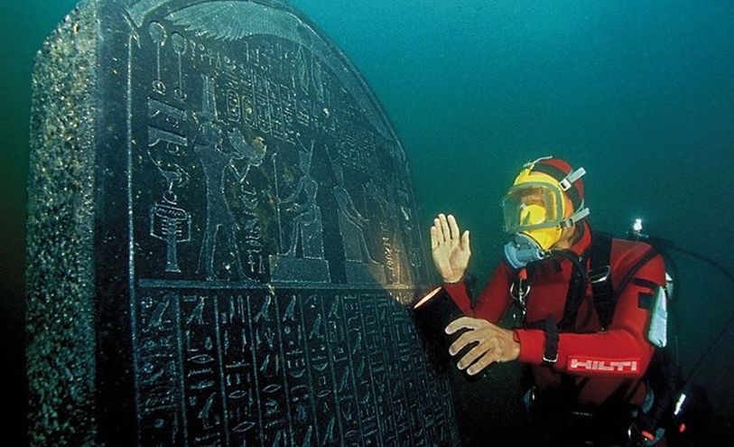 صورة لأحد الغواصين بجانب لوح يحتوي على كتابة فرعونية في قاع البحر- تويتر